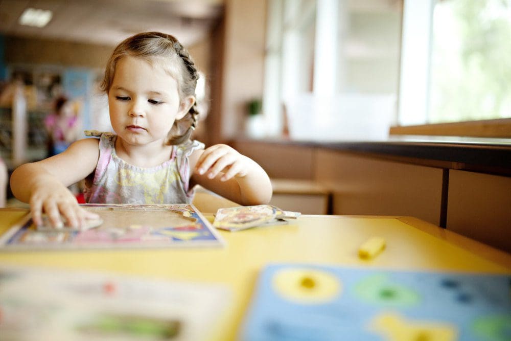 Little girl working on a puzzle.