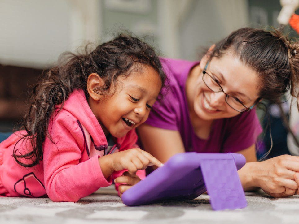 Mother and daughter playing on a tablet.