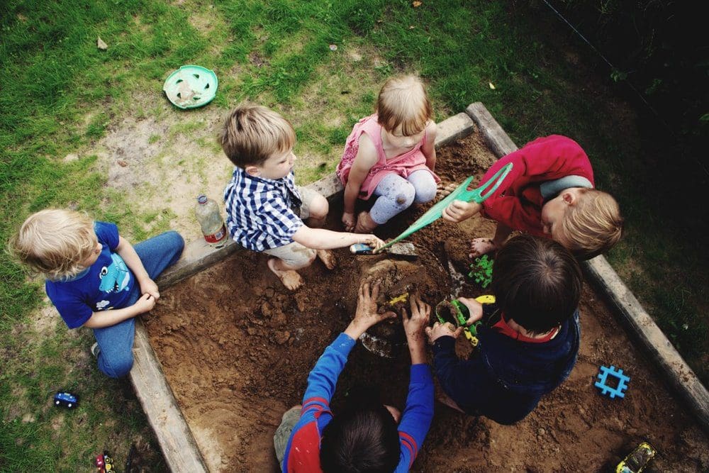 Children playing in a sand box.