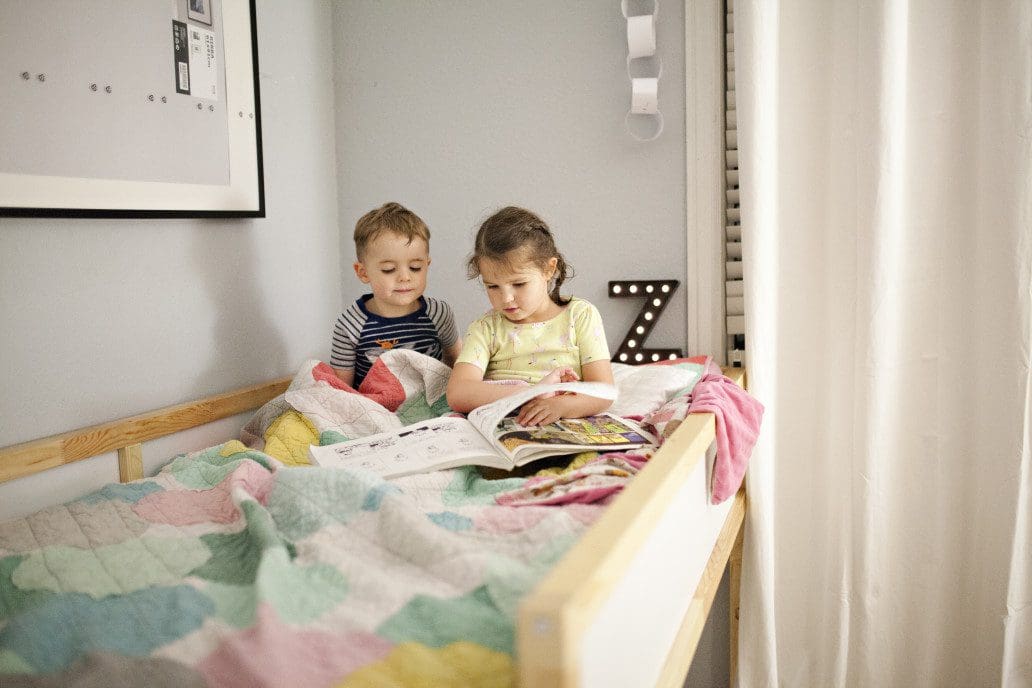 Two kids sitting in bed reading