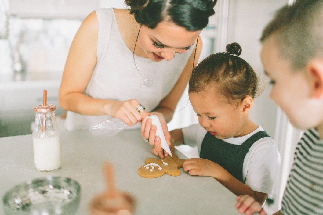 Mother decorating cookies with children.