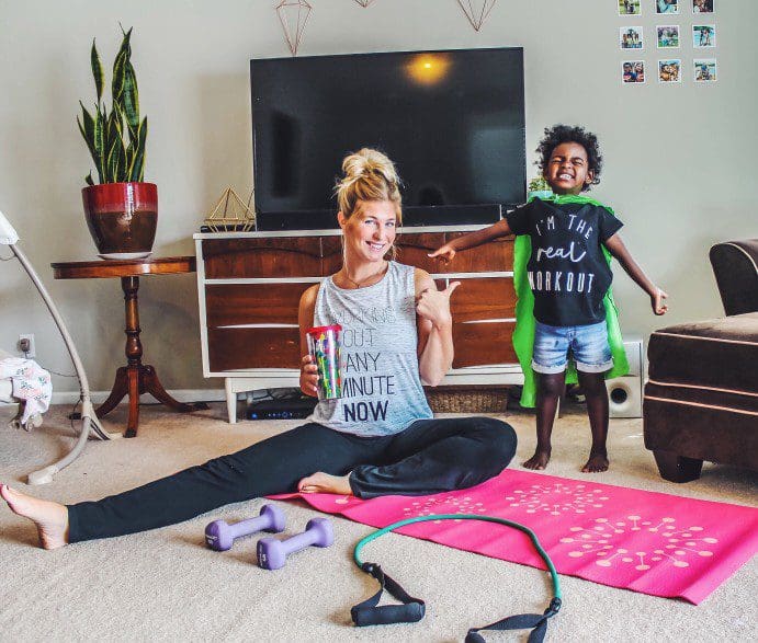 Mother working out with child near by.