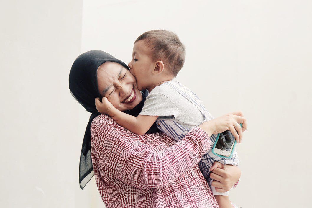 Mother holding child, laughing