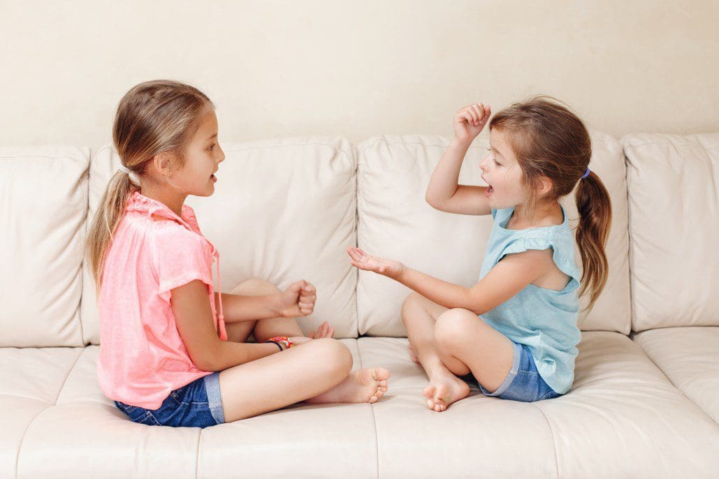 Children playing rock paper scissors.