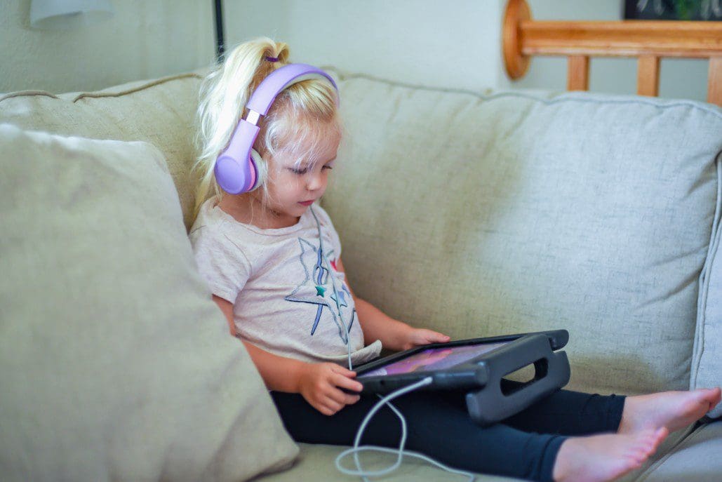 Child plays on tablet.