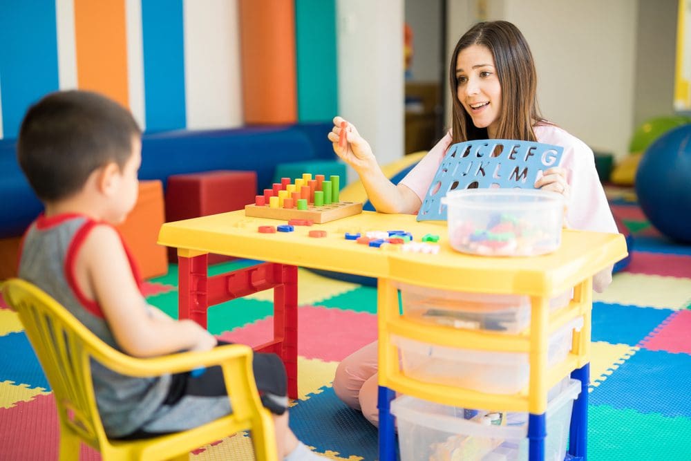 Special education teacher working through letters with young student